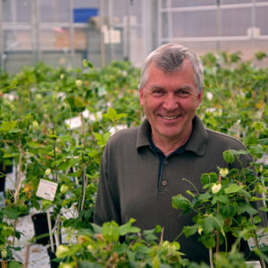 Professor Tor-Henning Iversen smiler bredt i det flotte Plantebiosenteret ved NTNU i Trondheim.